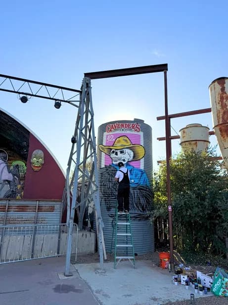 A steel art installation with a painted skull figure