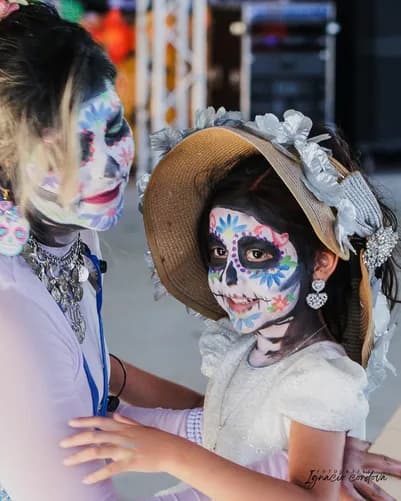 A child having their face painted as a calavera